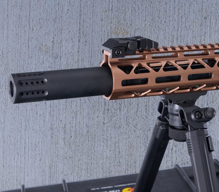Modern tactical rifle with bronze handguard, optic system, and bipod against gray background.