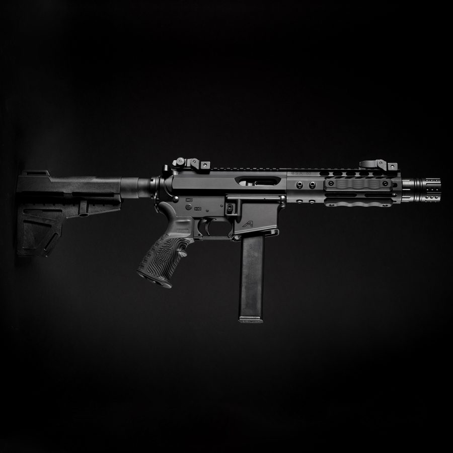 Modern AR-platform pistol caliber carbine with tactical features on black background, professional product photo.