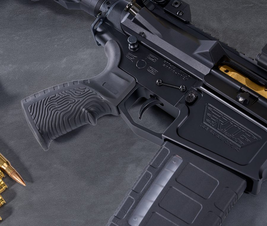 Close-up of AR-15 rifle receiver showcasing matte black finish and ergonomic grip.