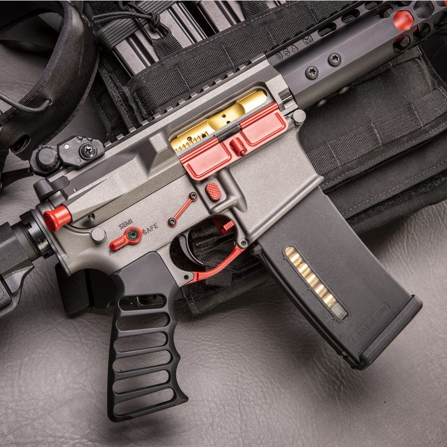 Custom Gray Airsoft Rifle with Red Accents on Tactical Vest for Enthusiasts.