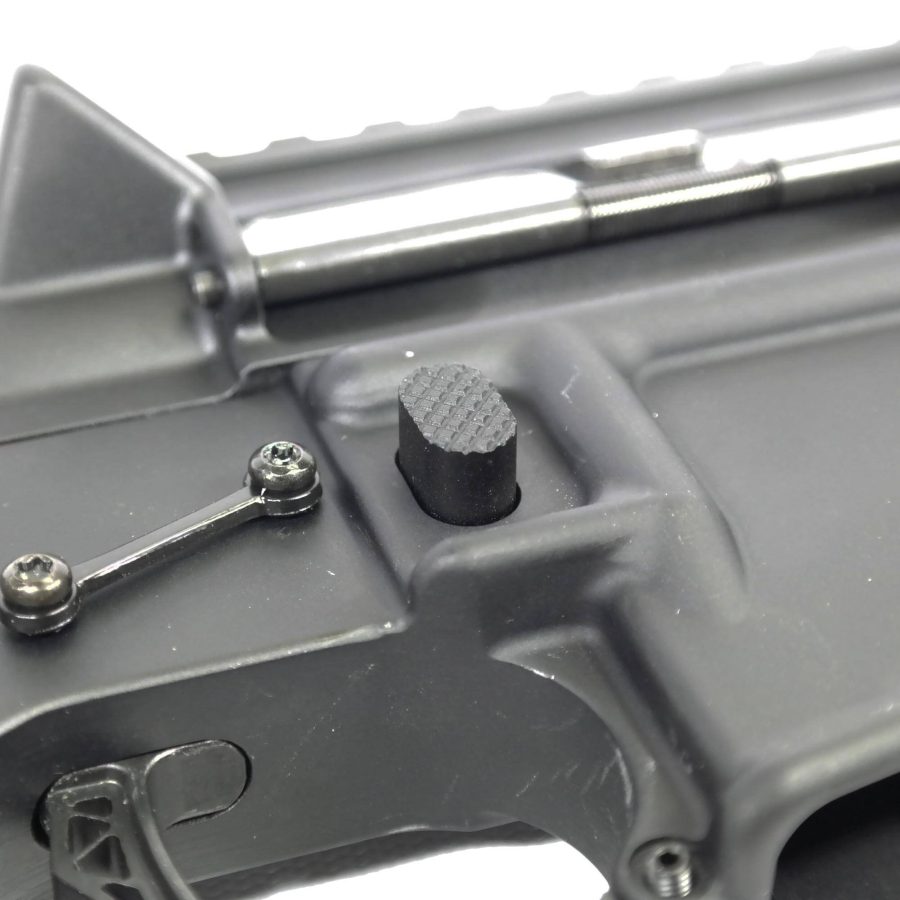 Close-up of AR-style rifle safety selector with matte gray finish and precise machining.