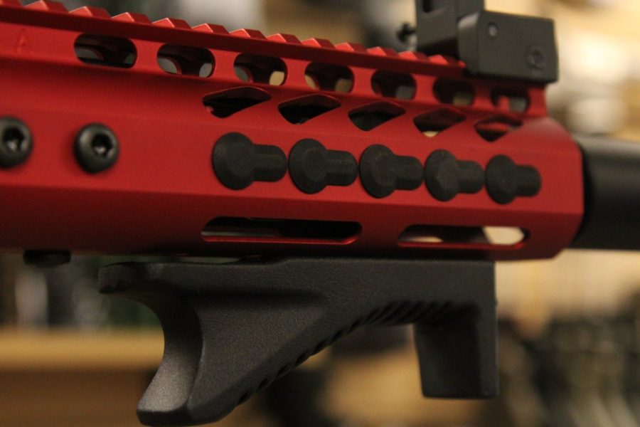 Close-up of a vibrant red AR-15 handguard showcasing mounting slots and precision cutouts.