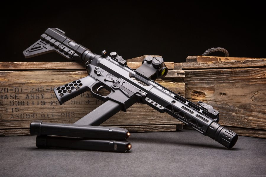 Modern tactical pistol caliber carbine contrasted with vintage military crate elements.