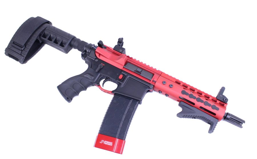 Red and black compact AR-style firearm with short barrel and modern design.