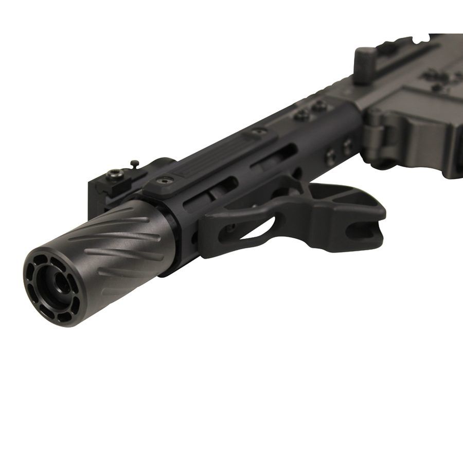 Close-up of tactical rifles fluted barrel and multi-port muzzle brake with accessory rails.