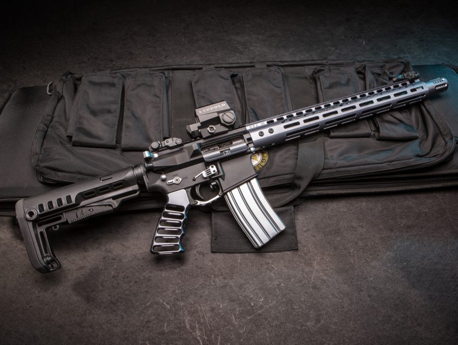 Custom AR-15 with red dot sight on padded case, showcasing tactical enhancements.