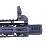 Close-up of tactical rifle barrel with flash hider, flip-up sight, and ventilated handguard.