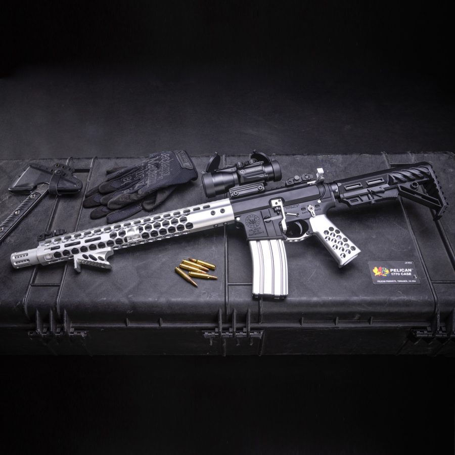 AR-style rifle with honeycomb handguard on black case, featuring brass ammo and optics.