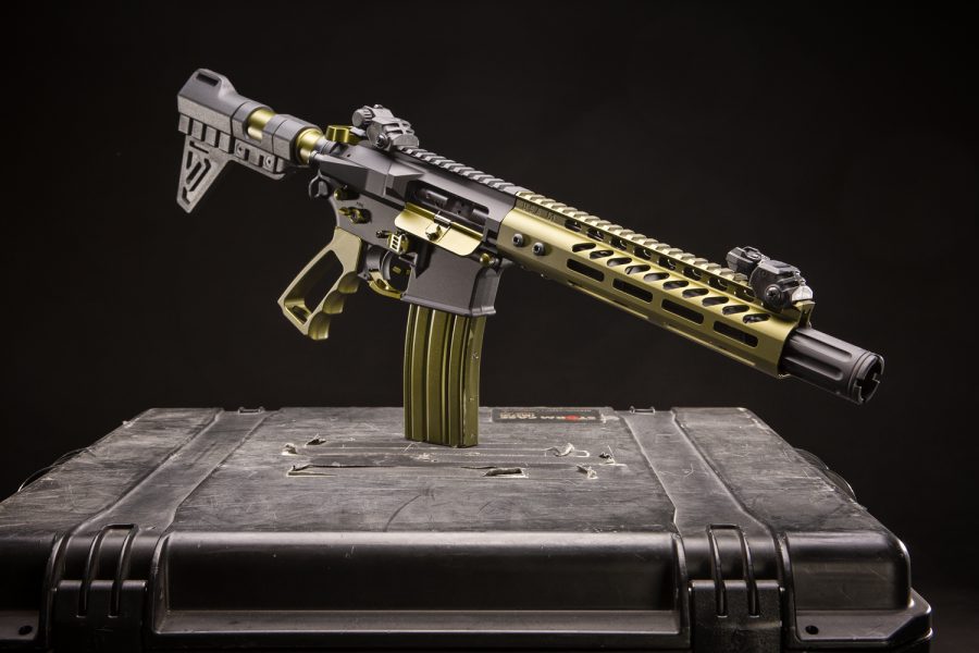 Modern AR-15 rifle in camouflage finish displayed on tactical case for marketing purposes.