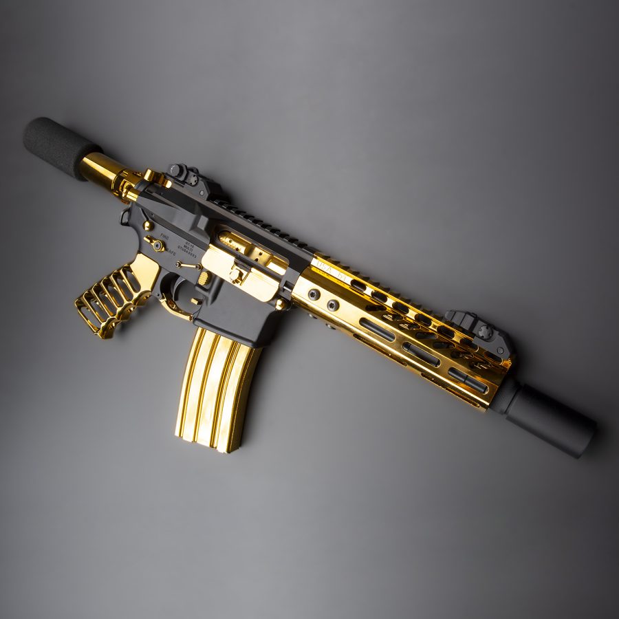 Luxury black and gold AR-15 rifle with custom design, matte body, and gold accents.