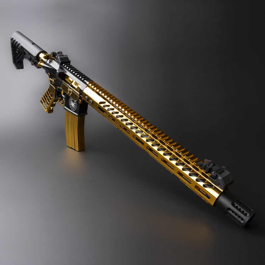 Custom gold and black AR-style rifle with aftermarket accessories against a gray background.