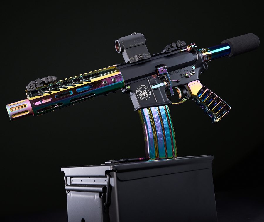 Custom AR-15 with iridescent rainbow PVD finish on a black background.