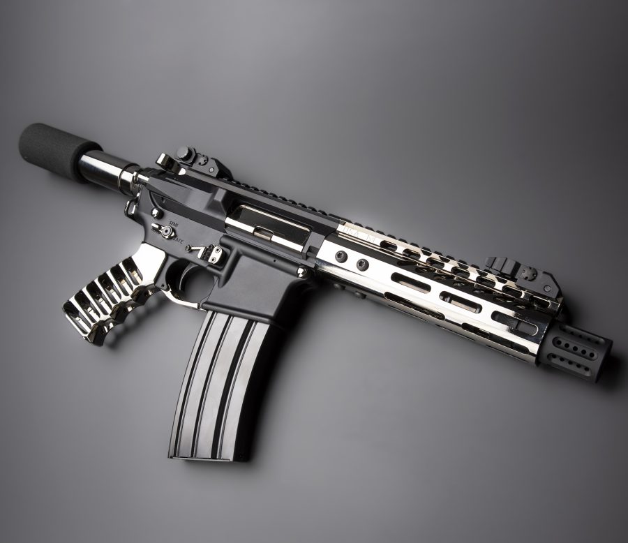Modern tactical rifle with suppressor and rail system showcased professionally against a gray background.