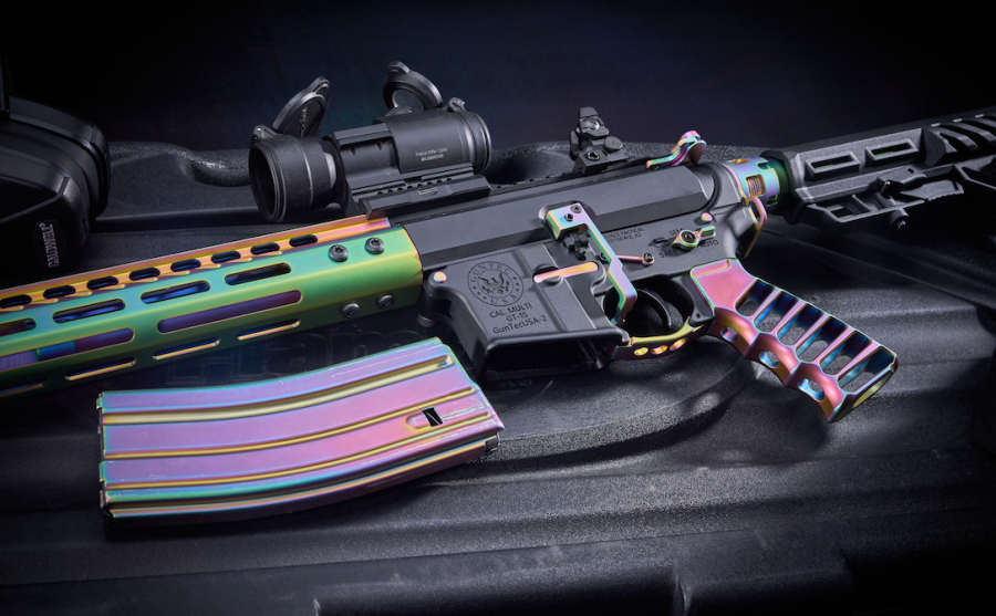 Custom iridescent tactical rifle with rainbow finish and accessories on black surface.