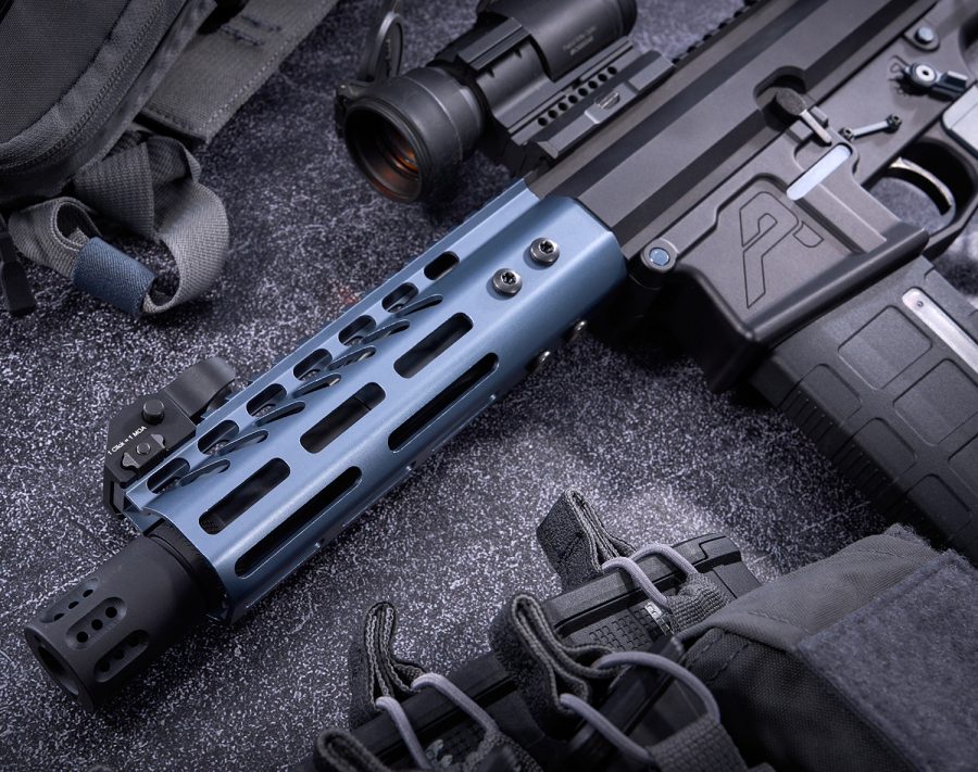 Custom AR-style rifle with blue handguard, scope, and tactical gear on display.