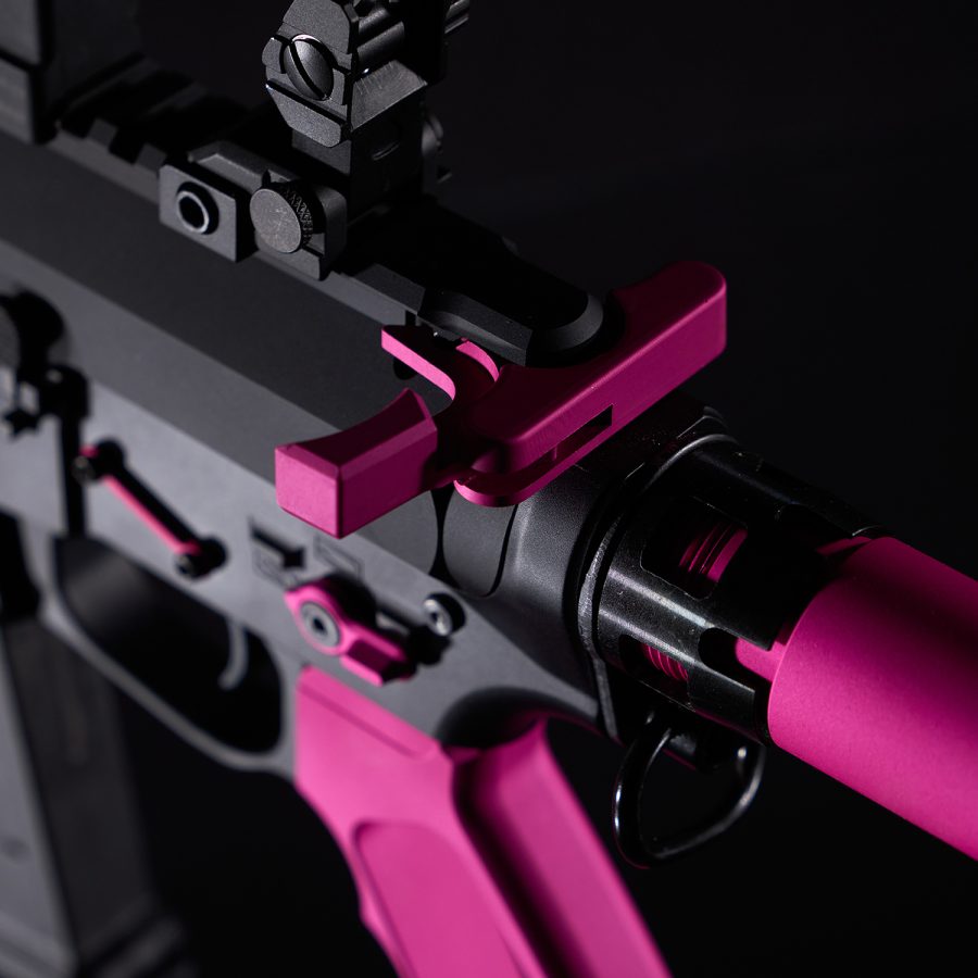 Close-up of high-quality black firearm with hot pink accents, emphasizing precision and style.