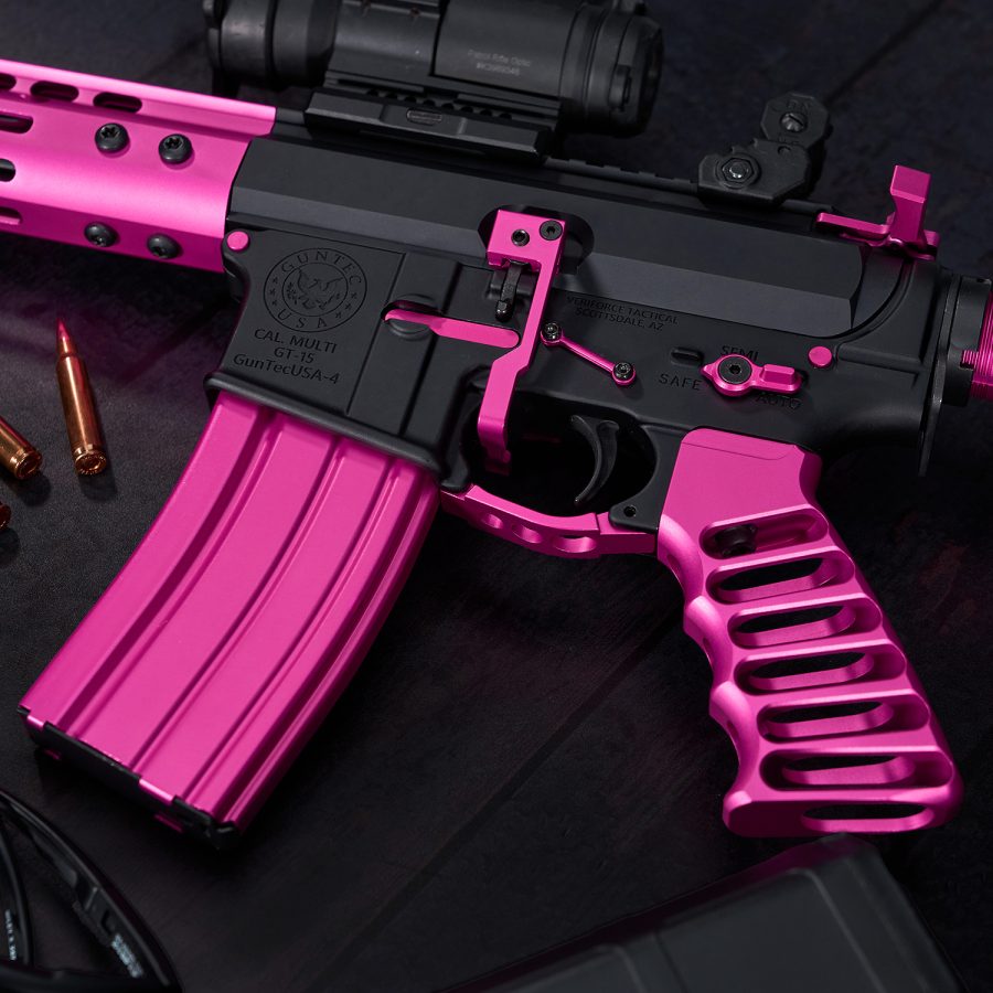 Black and pink AR-15 rifle with custom parts and optical sight for precision shooting.