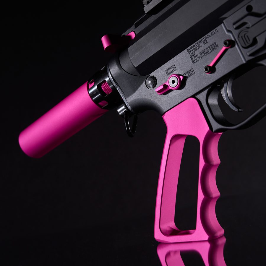 Custom AR-style firearm in matte black and hot pink against a black background.