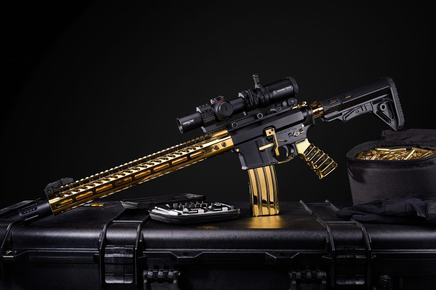 Gold AR rifle with scope on black case, highlighting luxury design and precision craftsmanship.