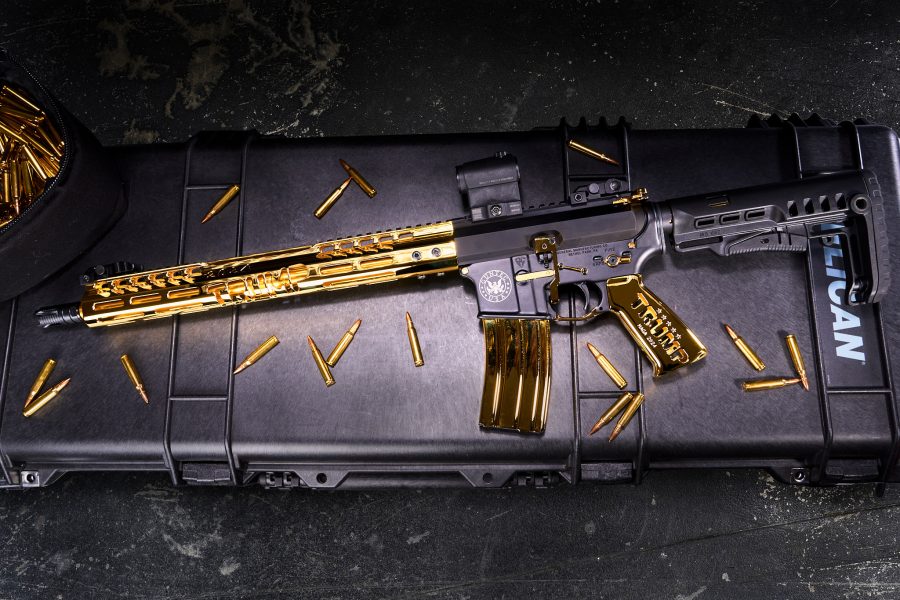 Gold-accented AR-15 rifle on padded case, showcasing tactical and luxury design elements.