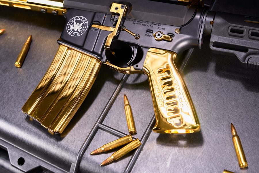 Gold-plated assault rifle with tactical design and brass bullets on a dark surface.