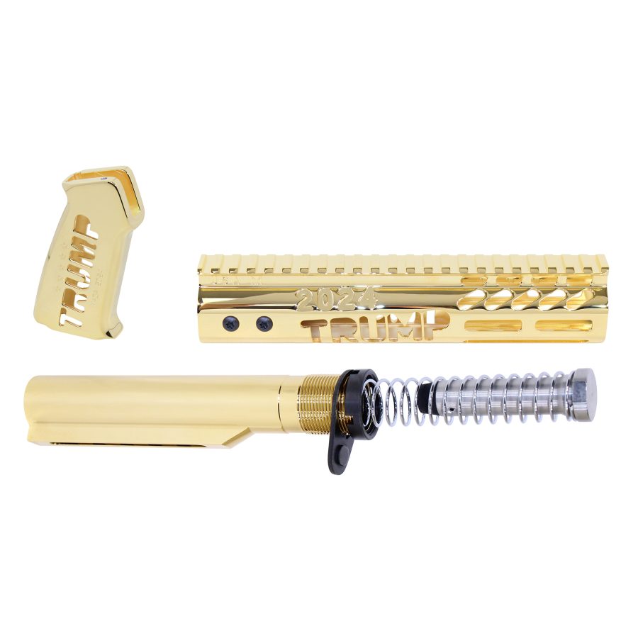 Gold-plated AR rifle parts engraved with TRUMP 2024 on a white background.